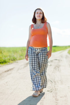 pregnant woman walking on  summer field