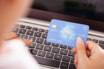 Female Holding Credit Card Over Keyboard