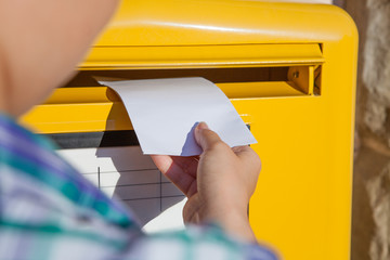 Woman inserting envelope in mailbox