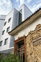 Ramshackle dilapidated old house and modern new building