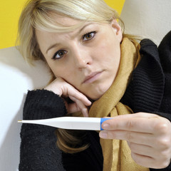 Kranke Frau hält Fieber-Thermometer
