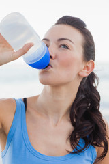 Close up view of woman drinking water after working out