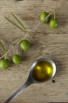olive branch and a spoon full of oil