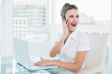 Happy businesswoman talking on the phone sitting