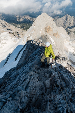 Young woman ascends mountain.