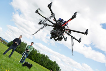 Technicians Operating UAV Helicopter in Park