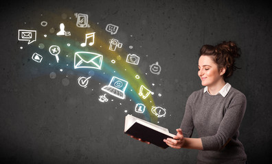 Young woman reading a book with multimedia icons coming out of t