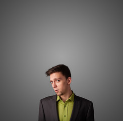 Thoughtful young businessman gesturing with copy space