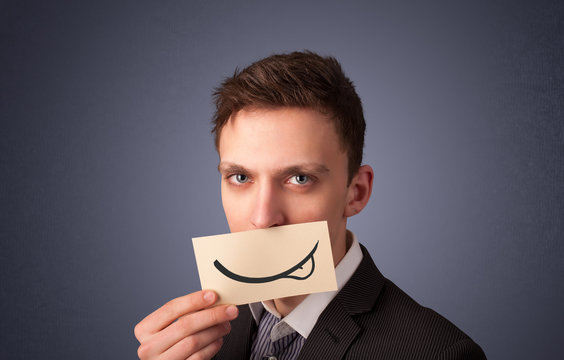 Happy businessman holding funny white card on his mouth