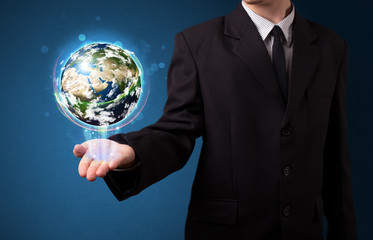 Businessman holding glowing earth globe