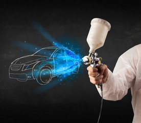 Worker with airbrush gun painting hand drawn car lines