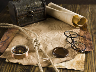 Compass, rope and glasses on old paper