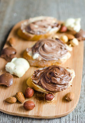 Obraz na płótnie Canvas Slices of bread with chocolate cream and nuts