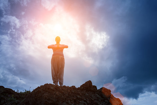 Woman In Yoga Meditation On Top Of Mountain