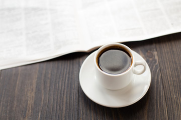 Newspaper and cup of coffee on table