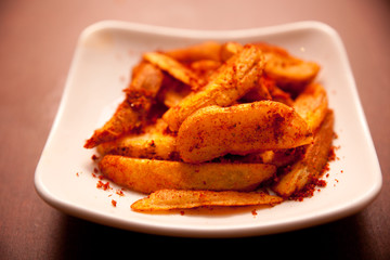 Fried potatoes, and a dish of chili powder