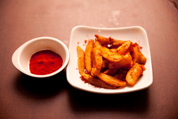 Fried potatoes, and a dish of chili powder