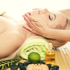 Obraz na płótnie Canvas A beautiful young woman receiving facial massage at a spa salon