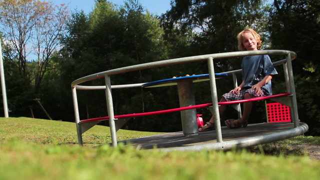 Kind auf Spielplatz-Karussel