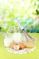 Ingredients for dough on wooden table on natural background