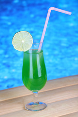 Tasty cocktail on swimming pool background