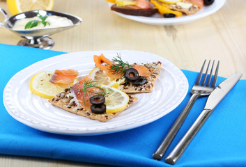 Salmon sandwiches on plate  on wooden table close-up