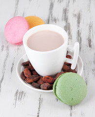 Cocoa drink, macaroni and cocoa beans on wooden background