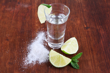 Tequila in glass on wooden table close-up