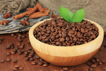 Coffee beans in bowl on wooden background
