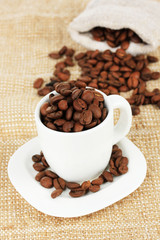 Coffee beans in cup on table close-up