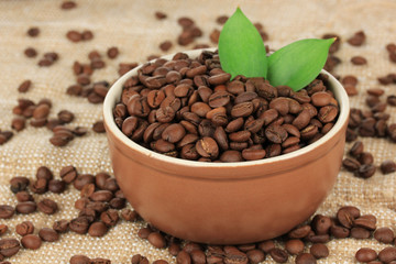 Coffee beans in bowl on table close-up