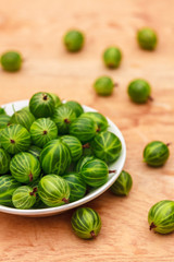 Close-Up Of Gooseberries In Vintage White Dish On Wooden Table