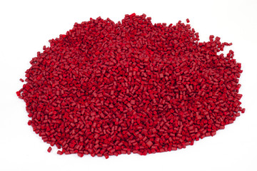 red plastic polymer granules on white background