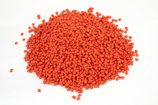 orange plastic polymer granules on white background
