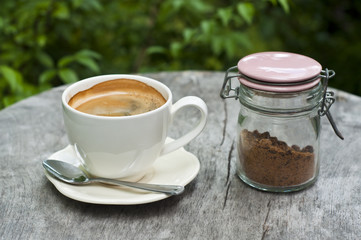 Cup of coffee with pot of brown sugar.