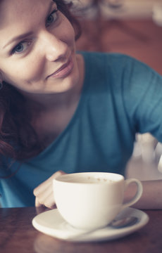 Redhead Women Sitting In The Cafee With Cup Of Coffee On The Tab