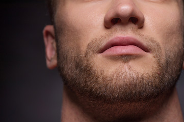 Obraz premium Mens face. Close-up cropped image of mens face isolated on grey