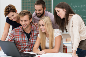 studenten schauen gemeinsam auf laptop