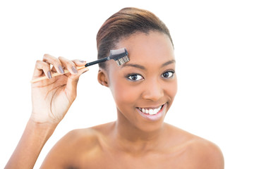 Fototapeta premium Smiling natural beauty using eyebrow brush