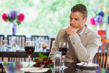 Handsome man waiting for his girlfriend at restaurant