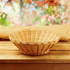 Fototapeta na wymiar Empty basket on wooden table over bokeh autumn background