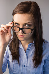 Serious brunette holding glasses posing