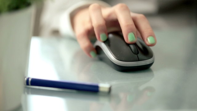 Woman hand using wireless mouse on reflective table