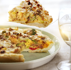 fresh baked quiche with one piece lifted out