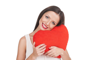 Girl with pillow. Beautiful young woman holding heart shape pill