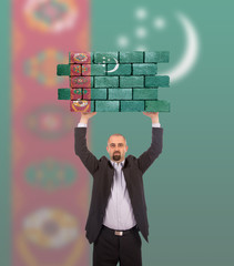 Businessman holding a large piece of a brick wall