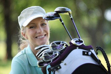 Fototapeta premium woman with a bag full of golf clubs