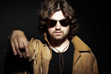 Cool rock style musician with long brown hair and beard. Holding