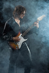 Psychedelic rock guitarist with long brown hair and beard. Dress