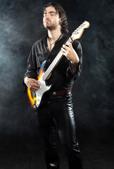 Psychedelic rock guitarist with long brown hair and beard. Dress